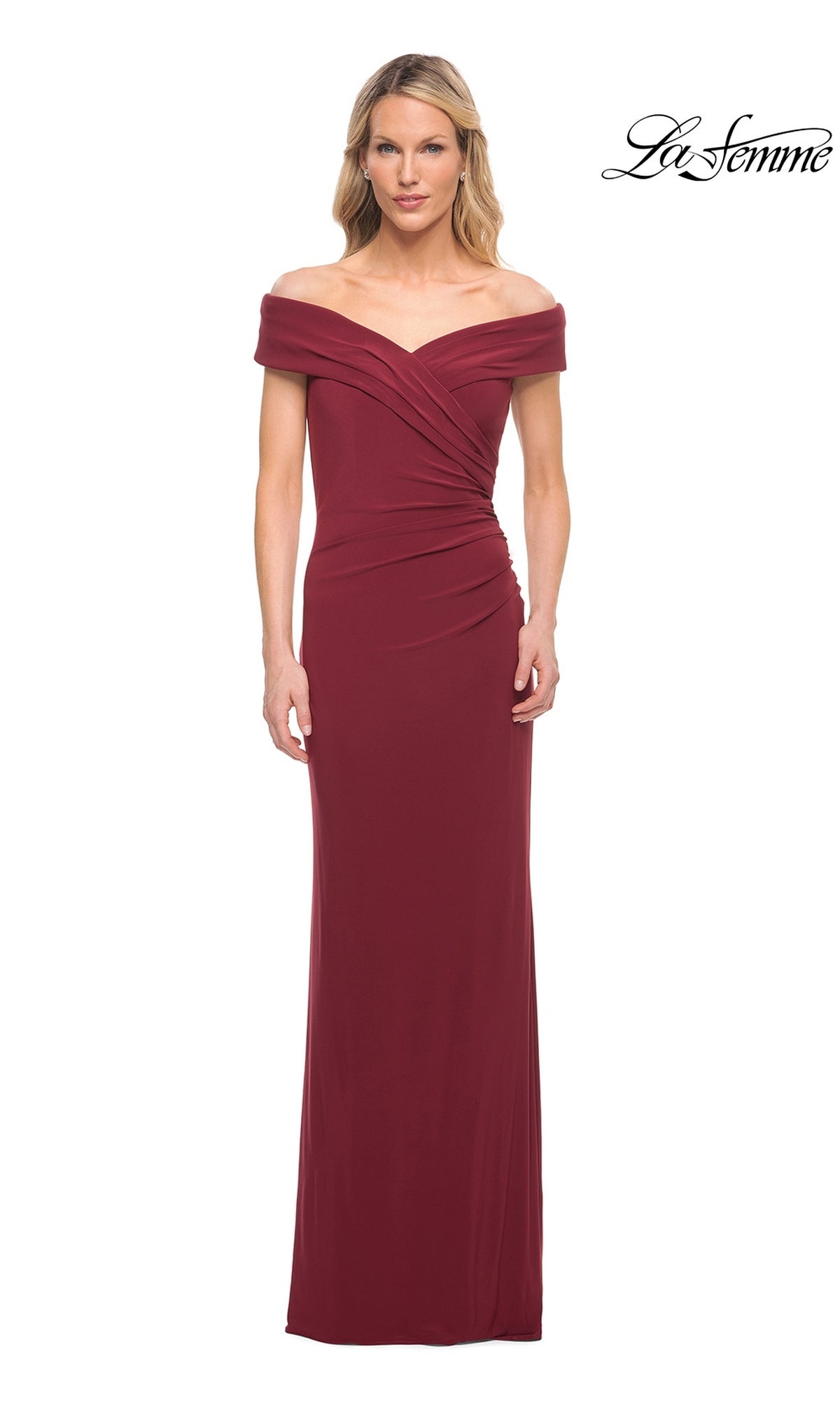 A woman wears the Long Formal Dress: La Femme 27959 in wine, featuring off-the-shoulder style, floor length, ruched details, and a fitted silhouette. The La Femme logo is in the top right.